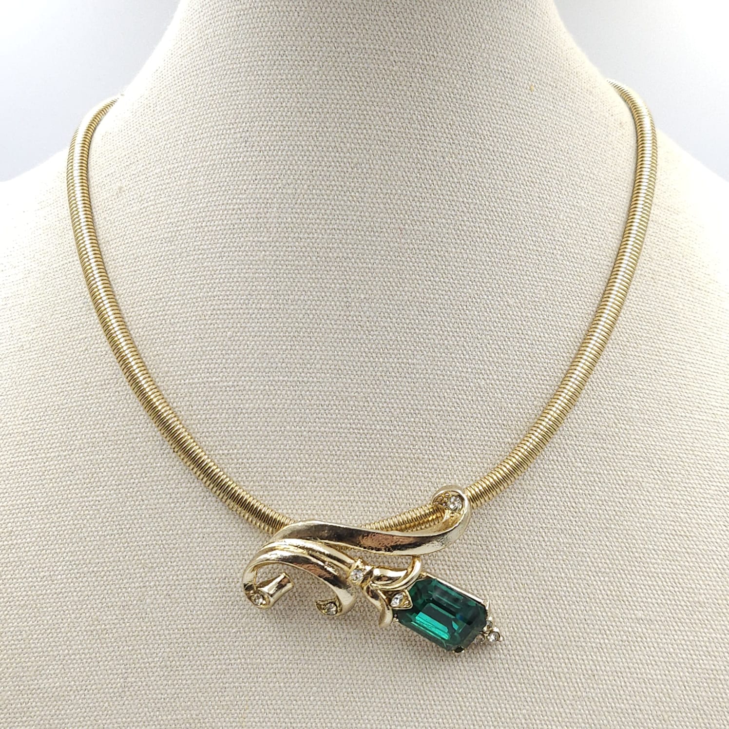 Collana anni '50 firmata Coro, con catena tipo tubogas e grande centrale di metallo color oro con un cristallo smeraldo taglio rettangolare e cristalli diamante rotondi - VINTAGE AMOREMIO