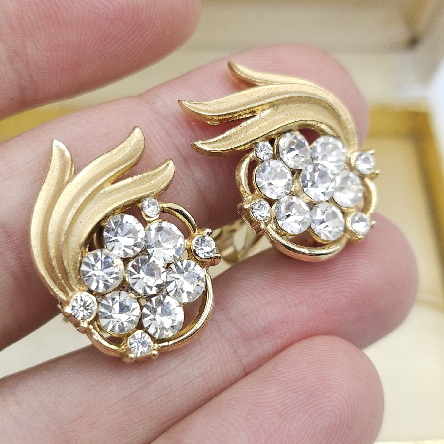 Orecchini a clip firmati Trifari, risalenti al 1960 circa, realizzati in lega Trifanium color oro satinato con particolari lucidi e cristalli diamante - VINTAGE AMORE MIO