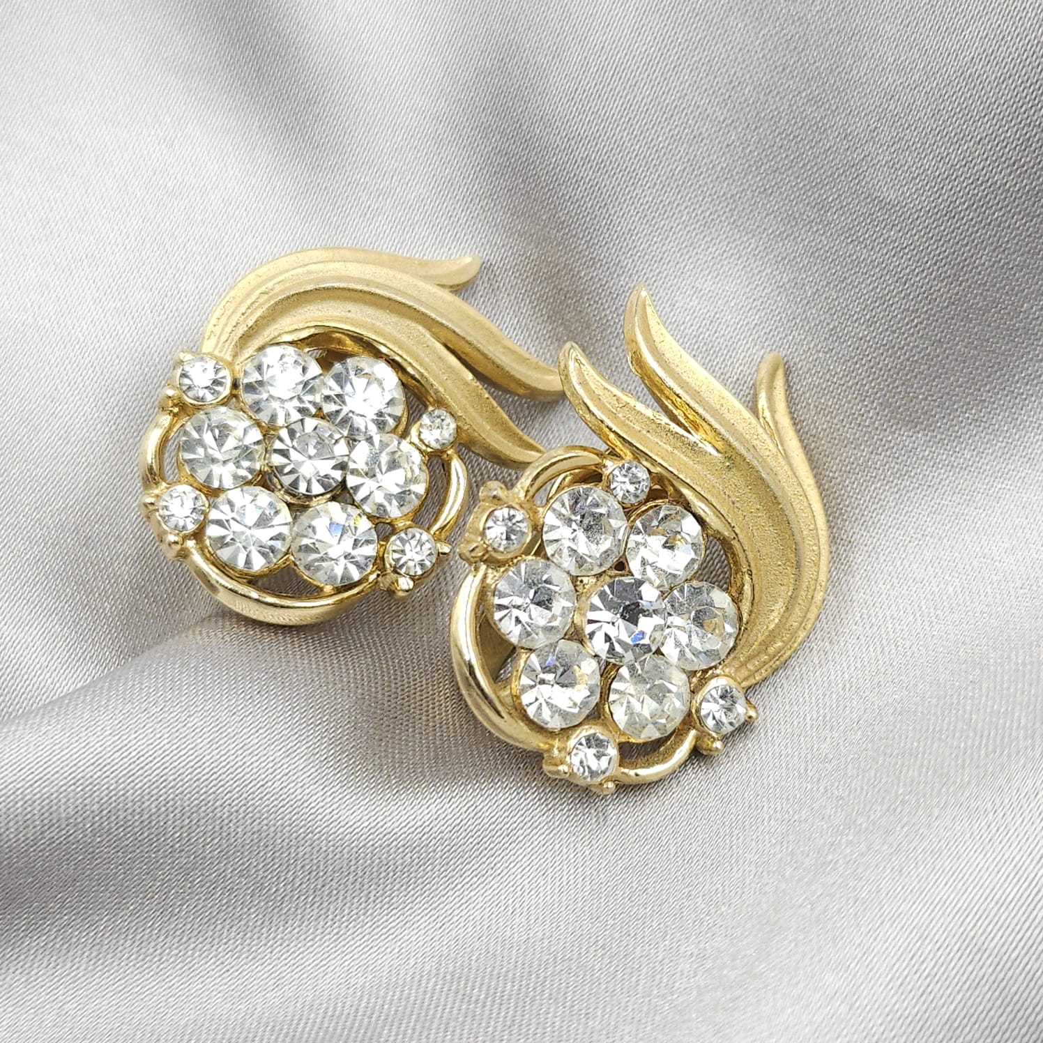 Orecchini a clip firmati Trifari, risalenti al 1960 circa, realizzati in lega Trifanium color oro satinato con particolari lucidi e cristalli diamante - VINTAGE AMORE MIO