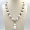 Collana di grandi perle bianche e grigie con chiusura gioiello