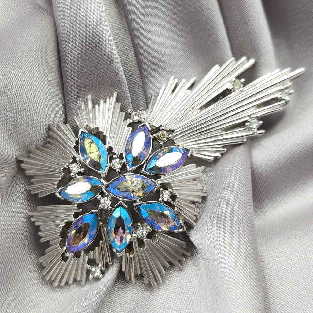 Spilla Trifari anni '50, realizzata in lega Trifanium color platino, con cristalli aurora borealis taglio navette tono azzurro e cristalli diamante rotondi - VINTAGE AMORE MIO