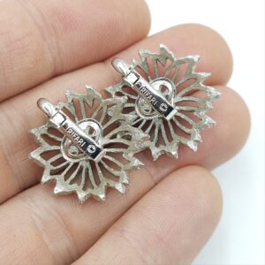 Orecchini a clip Trifari risalenti al 1960 circa, a forma di fiore stilizzato, realizzati in lega Trifanium color argento con lavorazione a cera persa e dettagli lucidi - VINTAGE AMORE MIO