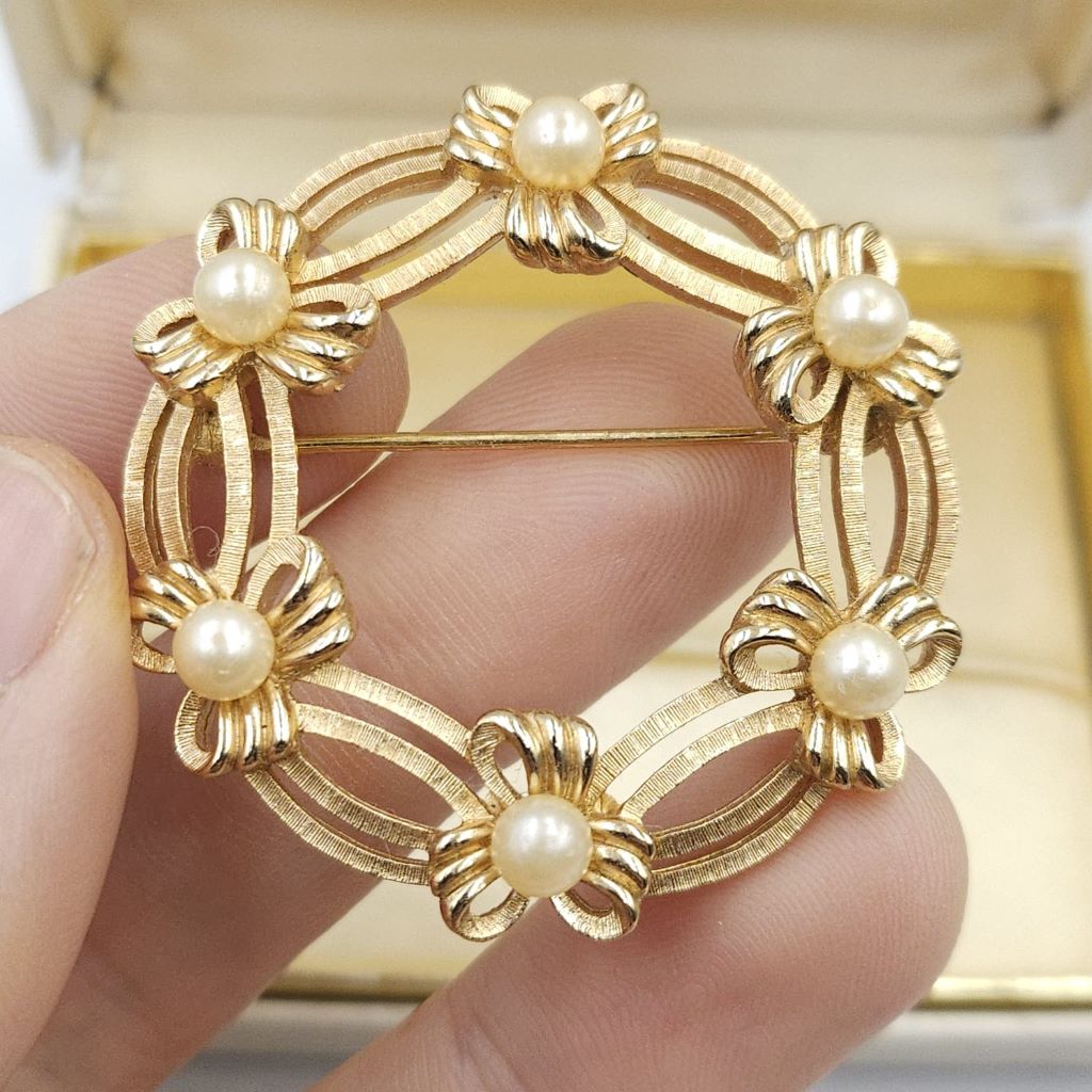 Spilla Trifari a forma di ghirlanda, realizzata alla fine degli anni '50, in lega Trifanium color oro satinato con dettagli lucidi e perle - VINTAGE AMORE MIO