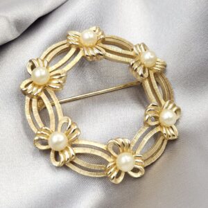 Spilla Trifari a forma di ghirlanda, realizzata alla fine degli anni '50, in lega Trifanium color oro satinato con dettagli lucidi e perle - VINTAGE AMORE MIO