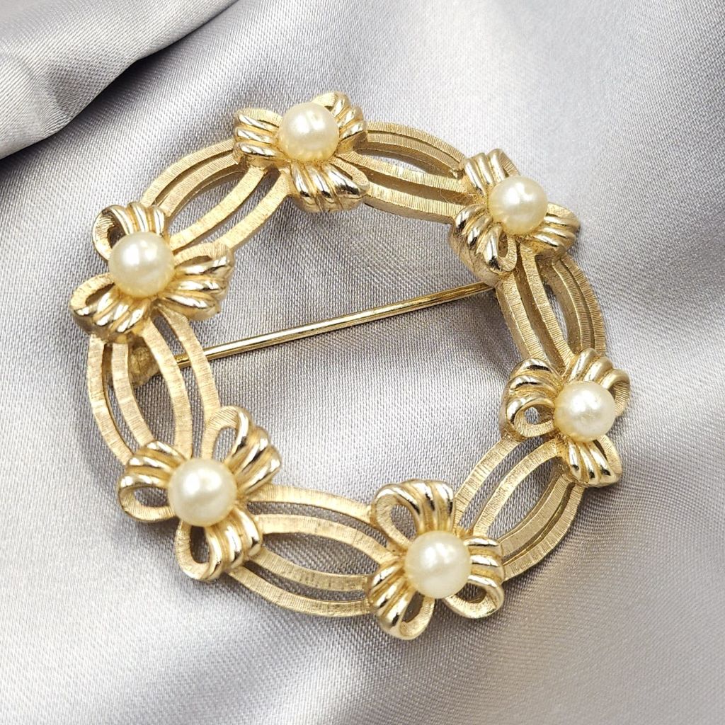 Spilla Trifari a forma di ghirlanda, realizzata alla fine degli anni '50, in lega Trifanium color oro satinato con dettagli lucidi e perle - VINTAGE AMORE MIO