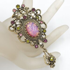 Spilla Sarah Coventry, predisposta per essere usata anche come pendente, anni '60 della serie "Contessa", realizzata in metallo color oro antico con cabochon di cristallo color opale e cristalli ametista, diamante e peridot - VINTAGE AMORE MIO