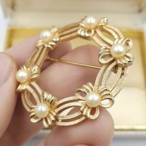 Spilla Trifari a forma di ghirlanda, realizzata alla fine degli anni '50, in lega Trifanium color oro satinato con dettagli lucidi e perle - VINTAGE AMORE MIO
