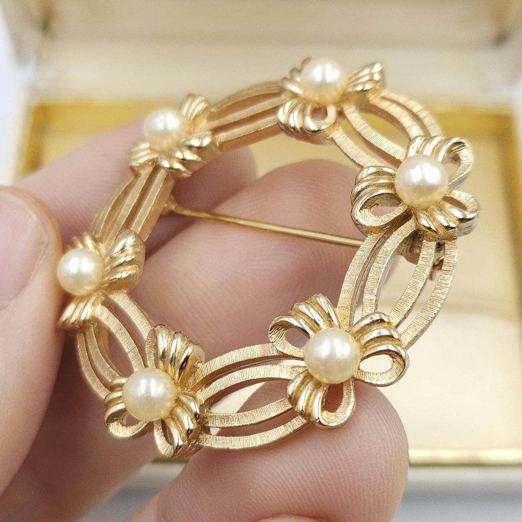 Spilla Trifari a forma di ghirlanda, realizzata alla fine degli anni '50, in lega Trifanium color oro satinato con dettagli lucidi e perle - VINTAGE AMORE MIO