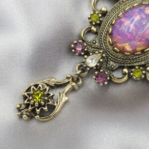 Spilla Sarah Coventry, predisposta per essere usata anche come pendente, anni '60 della serie "Contessa", realizzata in metallo color oro antico con cabochon di cristallo color opale e cristalli ametista, diamante e peridot - VINTAGE AMORE MIO