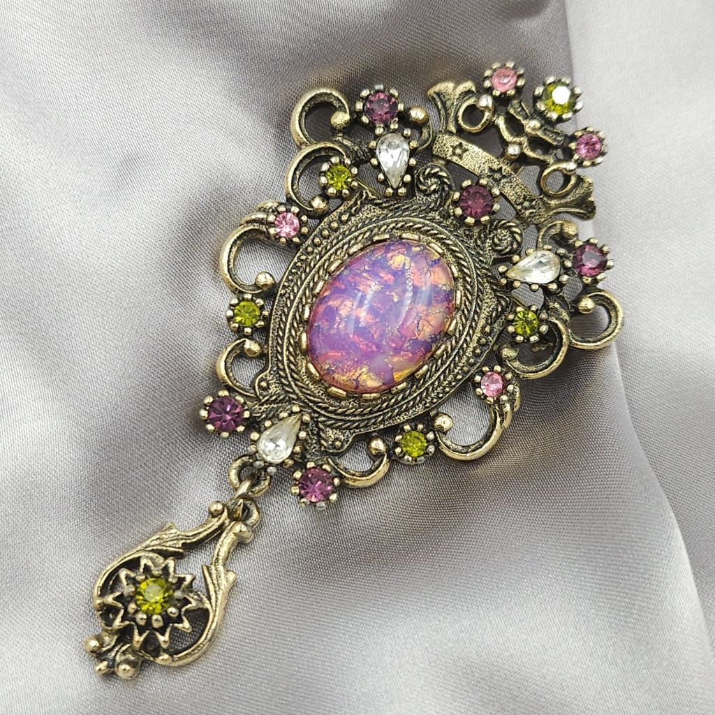 Spilla Sarah Coventry, predisposta per essere usata anche come pendente, anni '60 della serie "Contessa", realizzata in metallo color oro antico con cabochon di cristallo color opale e cristalli ametista, diamante e peridot - VINTAGE AMORE MIO