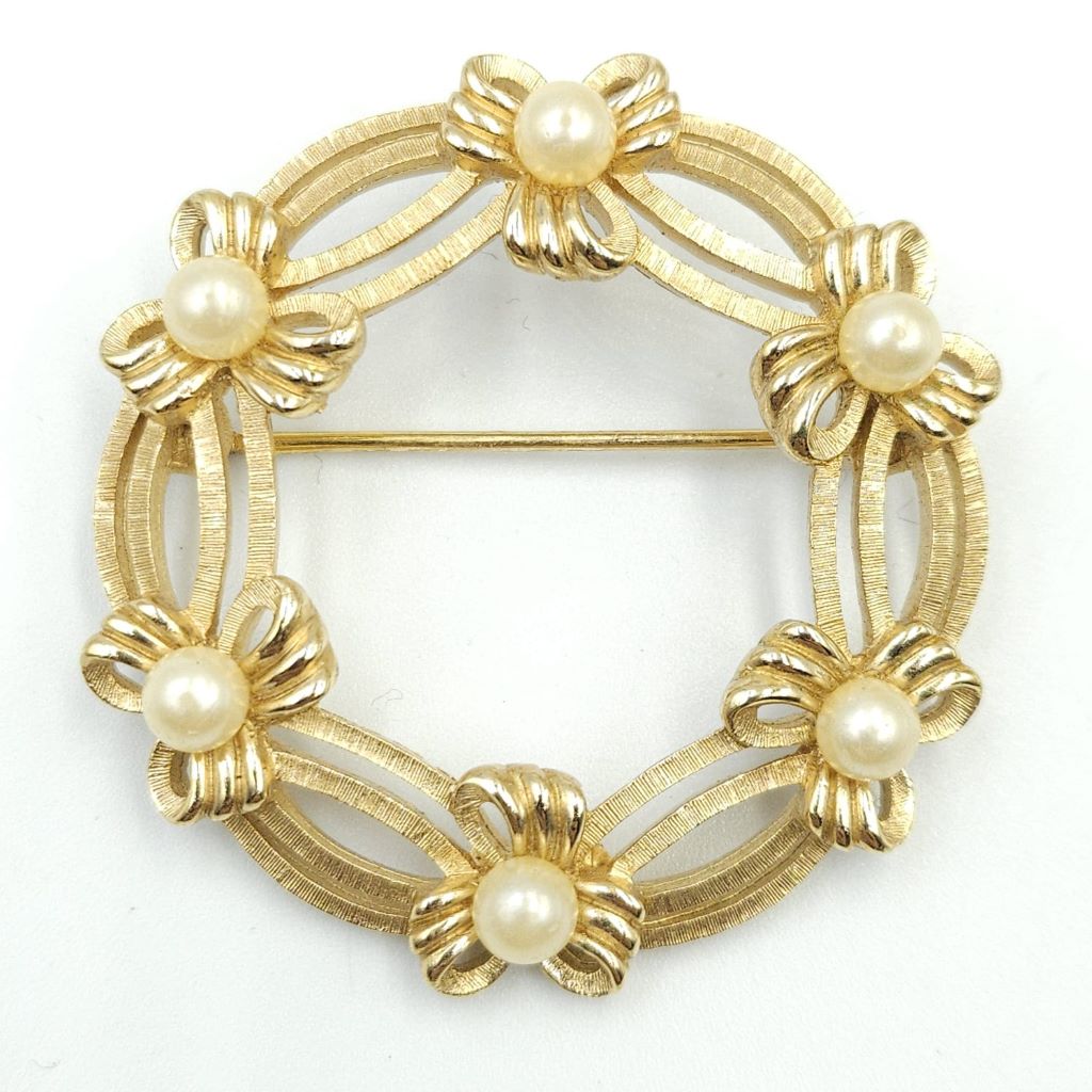 Spilla Trifari a forma di ghirlanda, realizzata alla fine degli anni '50, in lega Trifanium color oro satinato con dettagli lucidi e perle - VINTAGE AMORE MIO