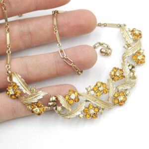 Collana anni '50 firmata Coro, con delicato decoro floreale, realizzata in metallo color oro con cristalli topazio e diamante - VINTAGE AMORE MIO Collana anni '50 firmata Coro, con delicato decoro floreale, realizzata in metallo color oro con cristalli topazio e diamante - VINTAGE AMORE MIO