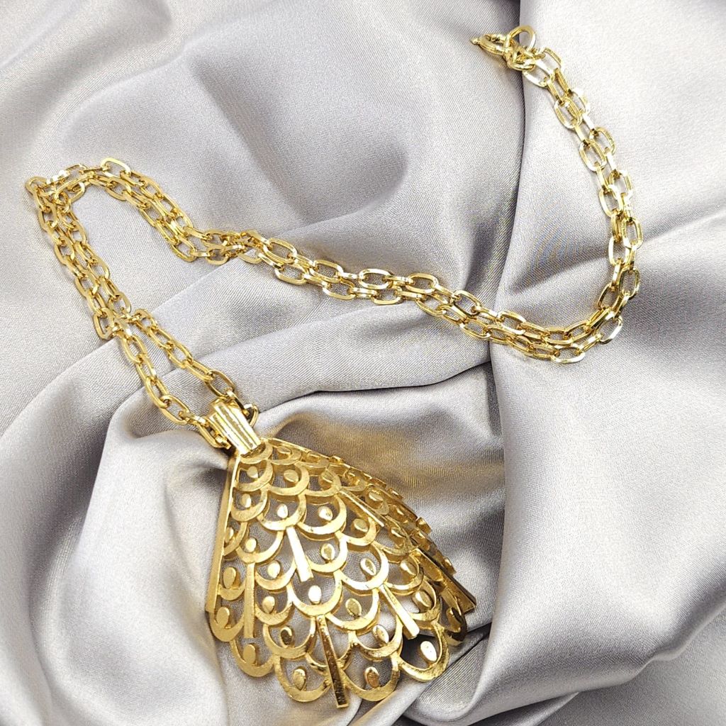 Collana firmata Trifari risalente al 1960 circa, composta da catena e grande pendente dalla forma convessa, realizzata in lega Trifanium color oro satinato con particolari lucidi - VINTAGE AMORE MIO