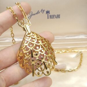 Collana firmata Trifari risalente al 1960 circa, composta da catena e grande pendente dalla forma convessa, realizzata in lega Trifanium color oro satinato con particolari lucidi - VINTAGE AMORE MIO