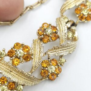 Collana anni '50 firmata Coro, con delicato decoro floreale, realizzata in metallo color oro con cristalli topazio e diamante - VINTAGE AMORE MIO Collana anni '50 firmata Coro, con delicato decoro floreale, realizzata in metallo color oro con cristalli topazio e diamante - VINTAGE AMORE MIO