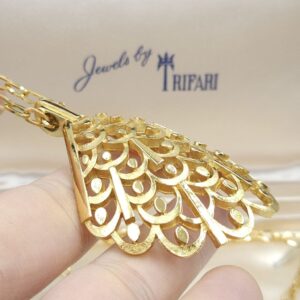 Collana firmata Trifari risalente al 1960 circa, composta da catena e grande pendente dalla forma convessa, realizzata in lega Trifanium color oro satinato con particolari lucidi - VINTAGE AMORE MIO