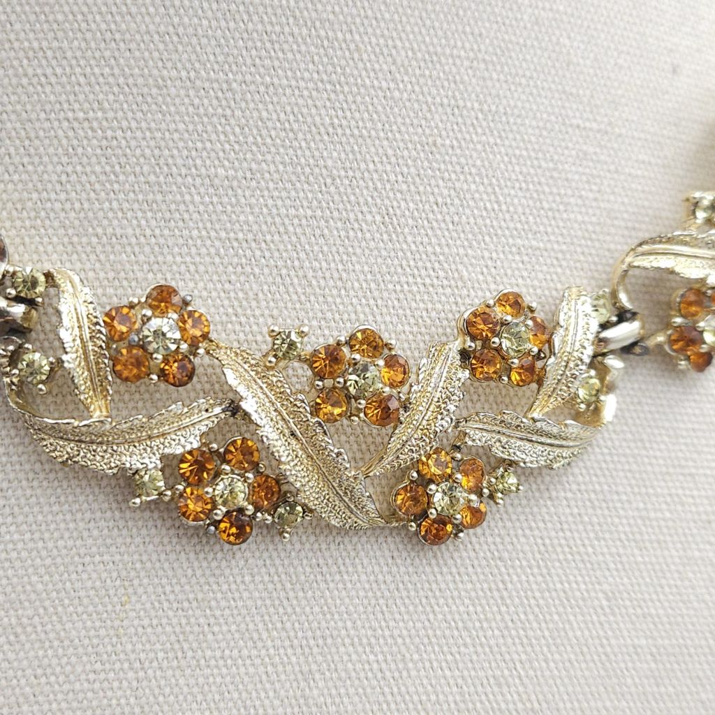 primopiano-collana-anni-50-firmata-coro-delicato-decoro-floreale-metallo-color-oro-cristalli-topazio-diamante Collana anni '50 firmata Coro, con delicato decoro floreale, realizzata in metallo color oro con cristalli topazio e diamante - VINTAGE AMORE MIO