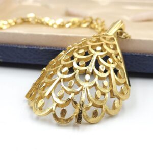 Collana firmata Trifari risalente al 1960 circa, composta da catena e grande pendente dalla forma convessa, realizzata in lega Trifanium color oro satinato con particolari lucidi - VINTAGE AMORE MIO