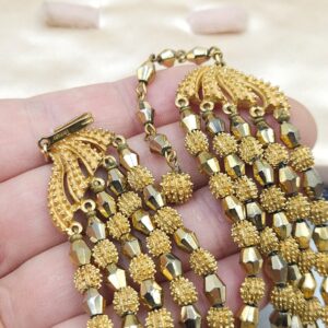 Parure Trifari della serie Electra realizzata nella seconda metà degli anni '50, composta da collana e bracciale, entrambi a cinque fili di pepite di lega Trifanium color oro - VINTAGE AMORE MIO