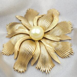 Grande e spettacolare spilla Trifari anni '50, realizzata in lega Trifanium color oro con lavorazione a bacchette e satinata, perla solitaria centrale - VINTAGE AMORE MIO