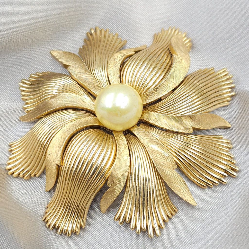 Grande e spettacolare spilla Trifari anni '50, realizzata in lega Trifanium color oro con lavorazione a bacchette e satinata, perla solitaria centrale - VINTAGE AMORE MIO
