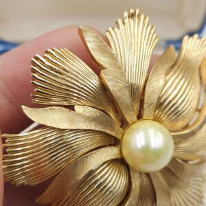 Grande e spettacolare spilla Trifari anni '50, realizzata in lega Trifanium color oro con lavorazione a bacchette e satinata, perla solitaria centrale - VINTAGE AMORE MIO