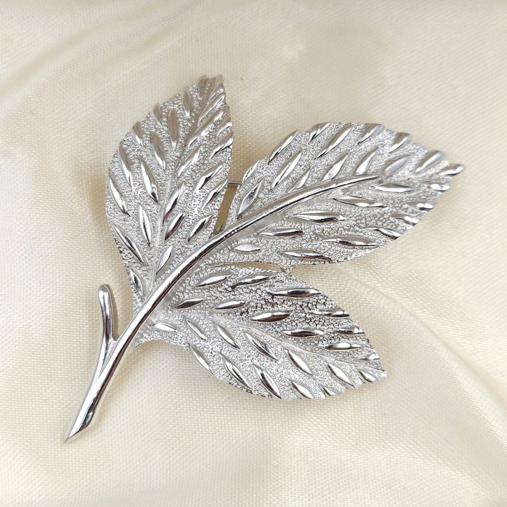 Spilla botanica firmata Trifari, realizzata verso il 1960, in lega Trifanium color argento satinato con dettagli lucidi - VINTAGE AMORE MIO