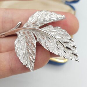 Spilla botanica firmata Trifari, realizzata verso il 1960, in lega Trifanium color argento satinato con dettagli lucidi - VINTAGE AMORE MIO