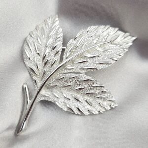 Spilla botanica firmata Trifari, realizzata verso il 1960, in lega Trifanium color argento satinato con dettagli lucidi - VINTAGE AMORE MIO