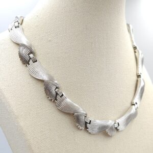 Collana firmata Trifari, risalente alla fine degli anni '50, con un affascinante decoro a onde, realizzata in lega Trifanium color argento con lavorazione a bacchette - VINTAGE AMORE MIO
