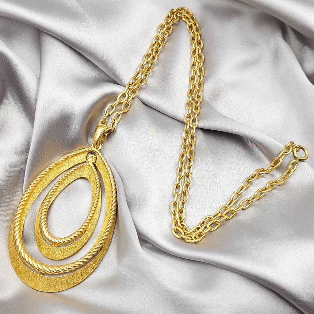 Collana firmata Trifari del 1960 circa con spessa catena e pendente snodato realizzato in lega Trifanium color oro con lavorazione satinata e profili a cordoncino - VINTAGE AMORE MIO