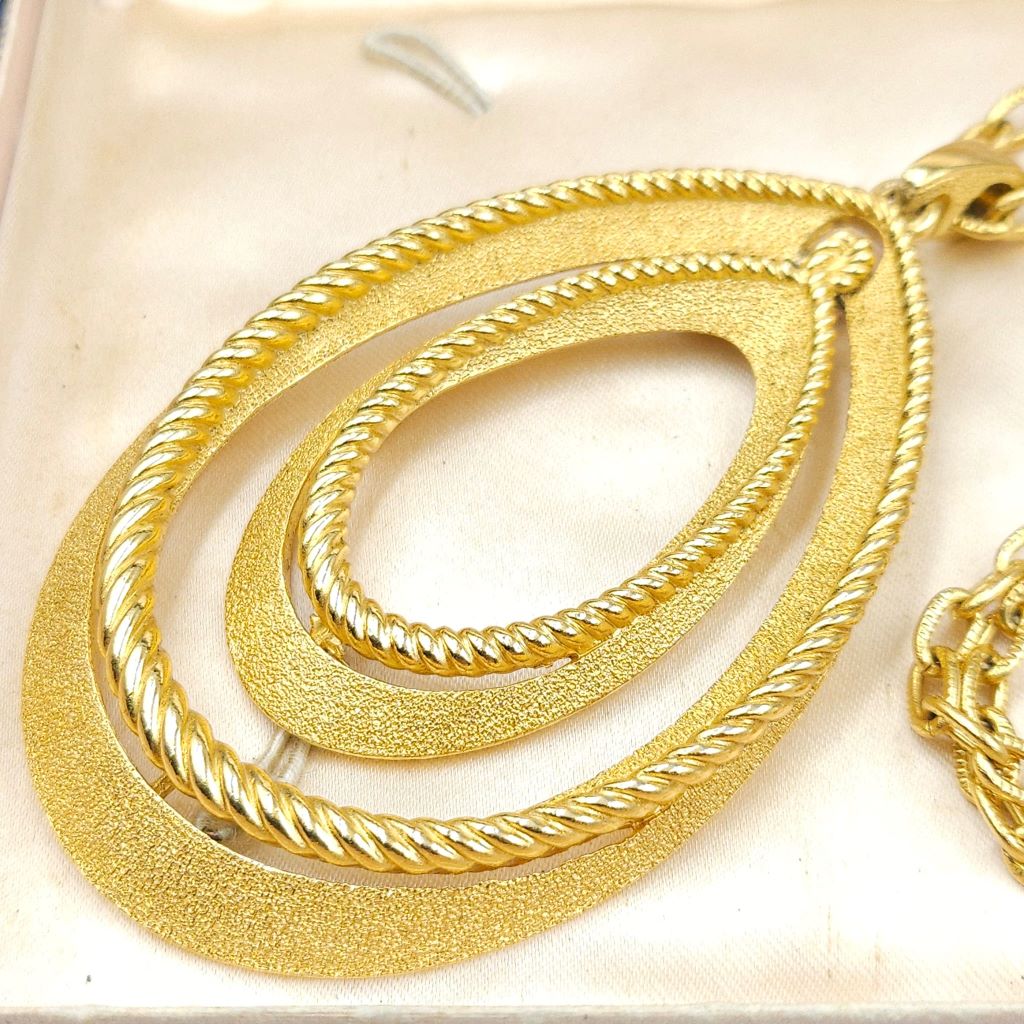 Collana firmata Trifari del 1960 circa con spessa catena e pendente snodato realizzato in lega Trifanium color oro con lavorazione satinata e profili a cordoncino - VINTAGE AMORE MIO