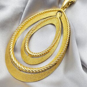 Collana firmata Trifari del 1960 circa con spessa catena e pendente snodato realizzato in lega Trifanium color oro con lavorazione satinata e profili a cordoncino - VINTAGE AMORE MIO