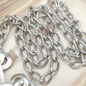 Collana firmata Trifari realizzata nei primissimi anni '60, composta da spessa catena e pendente a forma croce rielaborata, in lega Trifanium color argento satinato - VINTAGE AMORE MIO