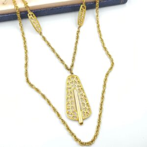 Collana firmata Trifari risalente al 1960 circa, con doppia catena e grande pendente, realizzata in lega Trifanium color oro con lavorazione a cera persa e dettagli lucidi - VINTAGE AMORE MIO