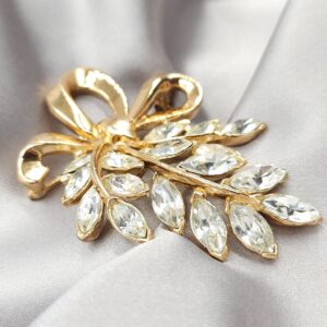 Spilla Trifari, risalente ai primi anni '50, realizzata in lega Trifanium color oro con cristalli diamante taglio navette, decoro con fiocco - VINTAGE AMORE MIO