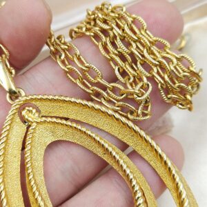 Collana firmata Trifari del 1960 circa con spessa catena e pendente snodato realizzato in lega Trifanium color oro con lavorazione satinata e profili a cordoncino - VINTAGE AMORE MIO