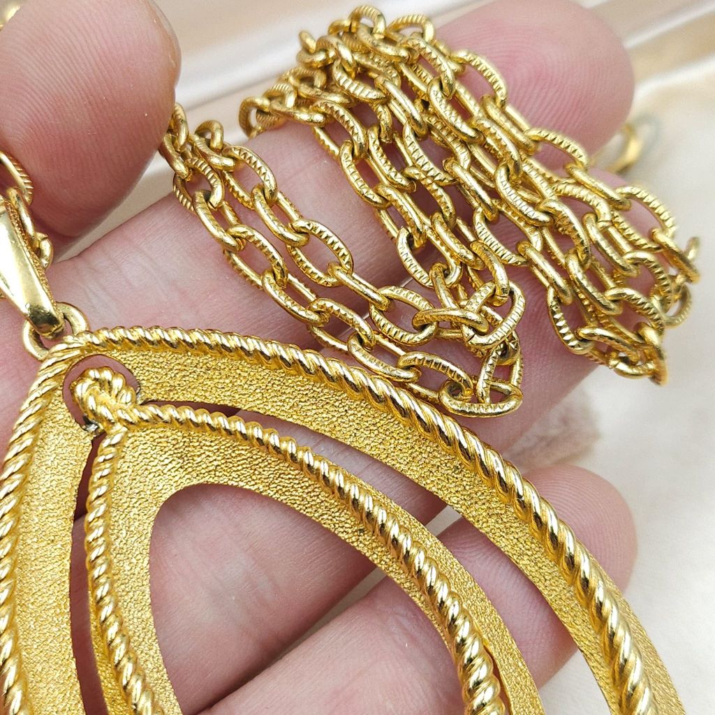 Collana firmata Trifari del 1960 circa con spessa catena e pendente snodato realizzato in lega Trifanium color oro con lavorazione satinata e profili a cordoncino - VINTAGE AMORE MIO