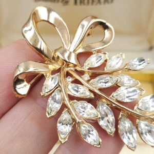 Spilla Trifari, risalente ai primi anni '50, realizzata in lega Trifanium color oro con cristalli diamante taglio navette, decoro con fiocco - VINTAGE AMORE MIO