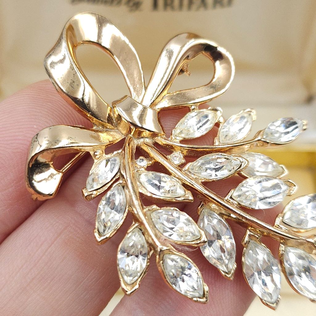 Spilla Trifari, risalente ai primi anni '50, realizzata in lega Trifanium color oro con cristalli diamante taglio navette, decoro con fiocco - VINTAGE AMORE MIO