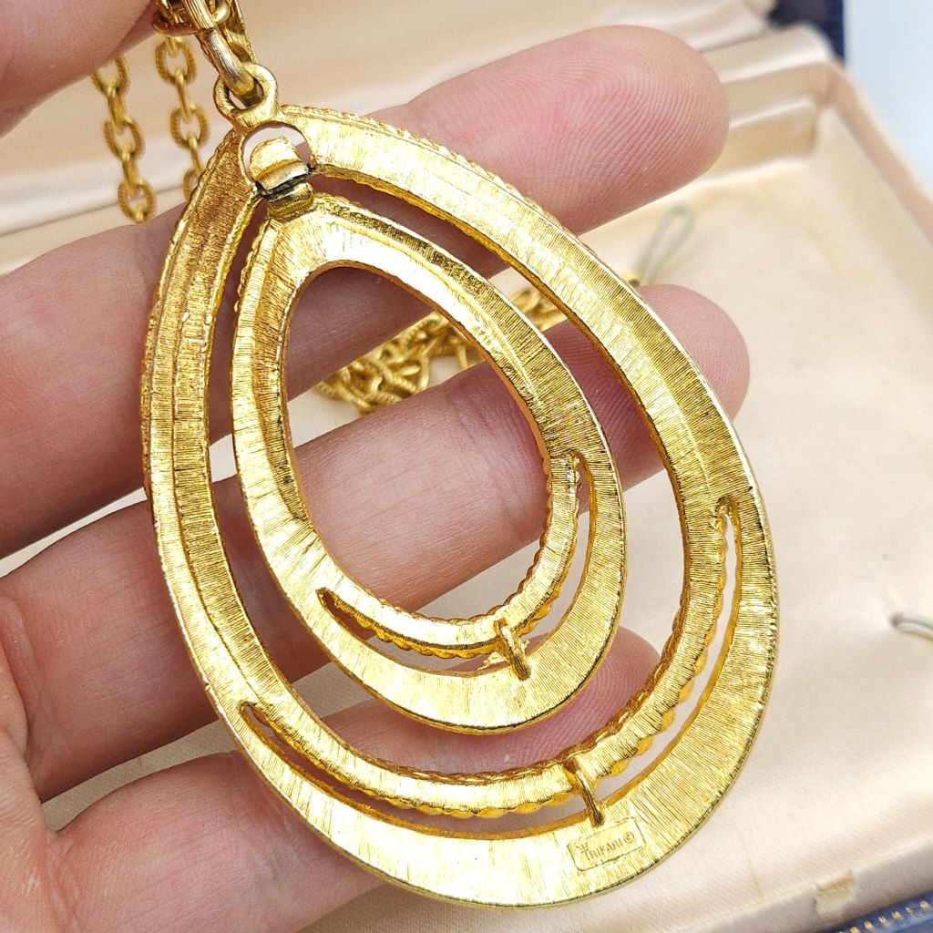 Collana firmata Trifari del 1960 circa con spessa catena e pendente snodato realizzato in lega Trifanium color oro con lavorazione satinata e profili a cordoncino - VINTAGE AMORE MIO