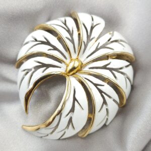 Spilla firmata Trifari risalente alla seconda metà degli anni '50, dalla forma bombata, realizzata in lega Trifanium color oro con smalto bianco - VINTAGE AMORE MIO