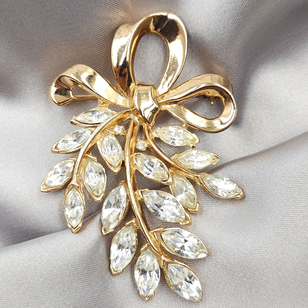 Spilla Trifari, risalente ai primi anni '50, realizzata in lega Trifanium color oro con cristalli diamante taglio navette, decoro con fiocco - VINTAGE AMORE MIO