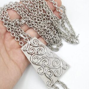 Collana Trifari risalente al 1960 circa, con doppia catena e grandissimo pendente in lega Trifanium color argento con lavorazione a cera persa e dettagli lucidi - VINTAGE AMORE MIO Collana Trifari risalente al 1960 circa, con doppia catena e grandissimo pendente in lega Trifanium color argento con lavorazione a cera persa e dettagli lucidi - VINTAGE AMORE MIO