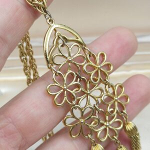 Collana waterfall firmata Trifari, risalente al 1960 circa, catena e grande pendente con decoro floreale in lega Trifanium color oro con tre nappe - VINTAGE AMORE MIO