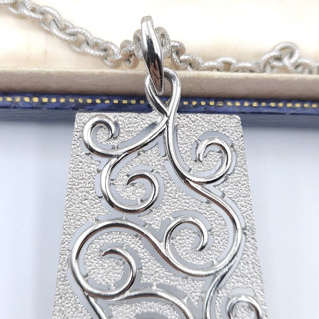 Collana Trifari risalente al 1960 circa, con doppia catena e grandissimo pendente in lega Trifanium color argento con lavorazione a cera persa e dettagli lucidi - VINTAGE AMORE MIO Collana Trifari risalente al 1960 circa, con doppia catena e grandissimo pendente in lega Trifanium color argento con lavorazione a cera persa e dettagli lucidi - VINTAGE AMORE MIO