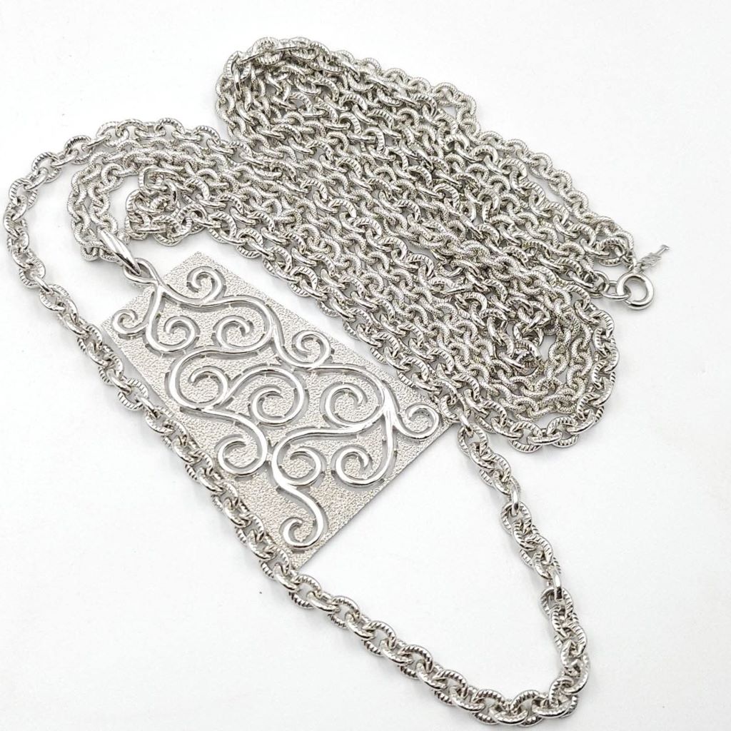 Collana Trifari risalente al 1960 circa, con doppia catena e grandissimo pendente in lega Trifanium color argento con lavorazione a cera persa e dettagli lucidi - VINTAGE AMORE MIO Collana Trifari risalente al 1960 circa, con doppia catena e grandissimo pendente in lega Trifanium color argento con lavorazione a cera persa e dettagli lucidi - VINTAGE AMORE MIO