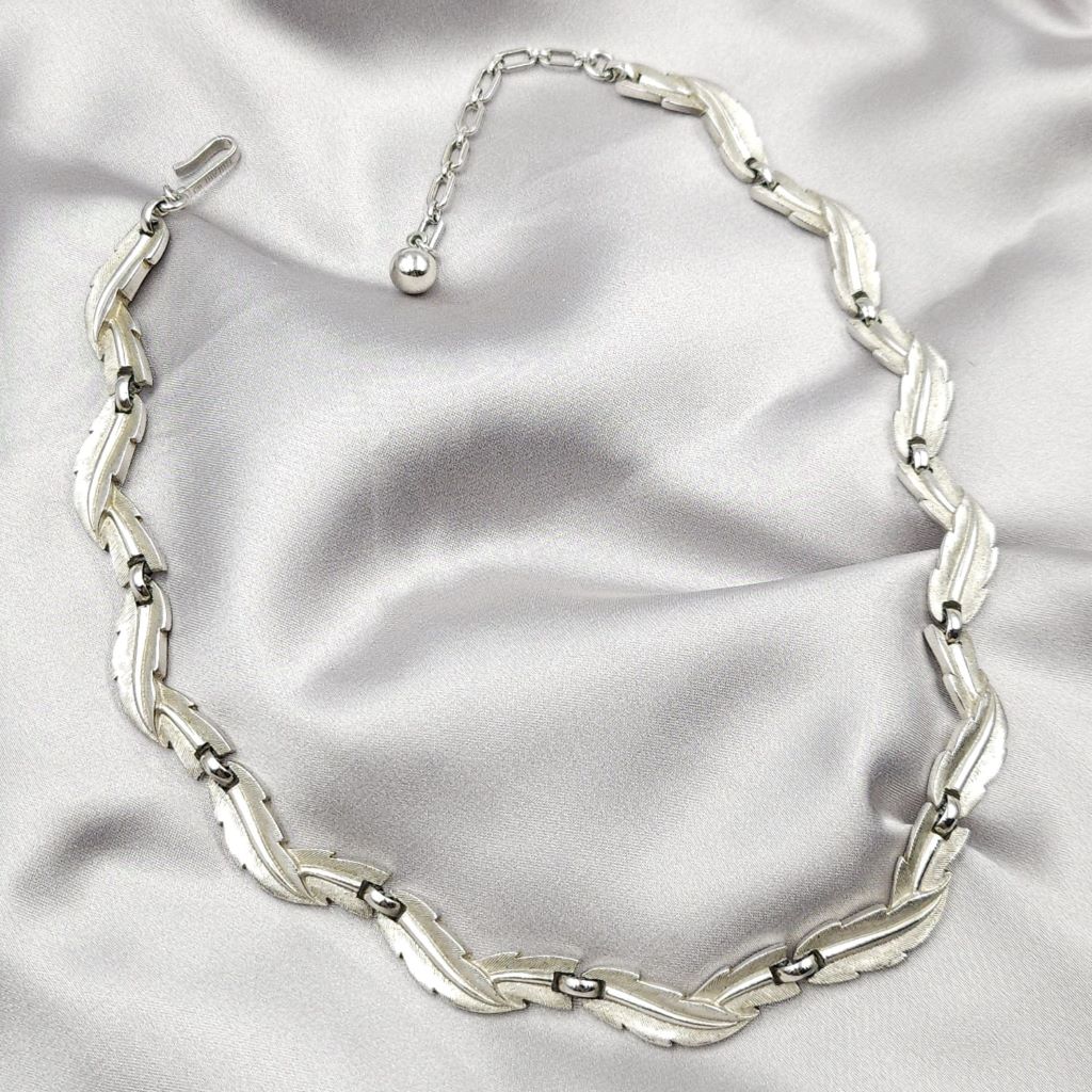 Collana firmata Trifari risalente ai primissimi anni '60, con decoro di foglie in lega Trifanium color argento satinato con venature lucide - VINTAGE AMORE MIO Collana firmata Trifari risalente ai primissimi anni '60, con decoro di foglie in lega Trifanium color argento satinato con venature lucide - VINTAGE AMORE MIO