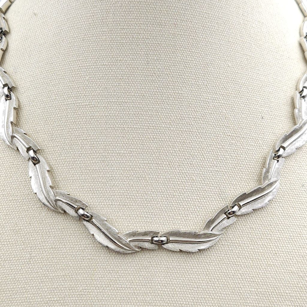 Collana firmata Trifari risalente ai primissimi anni '60, con decoro di foglie in lega Trifanium color argento satinato con venature lucide - VINTAGE AMORE MIO Collana firmata Trifari risalente ai primissimi anni '60, con decoro di foglie in lega Trifanium color argento satinato con venature lucide - VINTAGE AMORE MIO