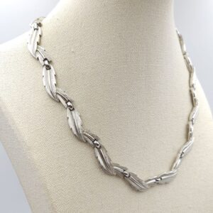 Collana firmata Trifari risalente ai primissimi anni '60, con decoro di foglie in lega Trifanium color argento satinato con venature lucide - VINTAGE AMORE MIO Collana firmata Trifari risalente ai primissimi anni '60, con decoro di foglie in lega Trifanium color argento satinato con venature lucide - VINTAGE AMORE MIO